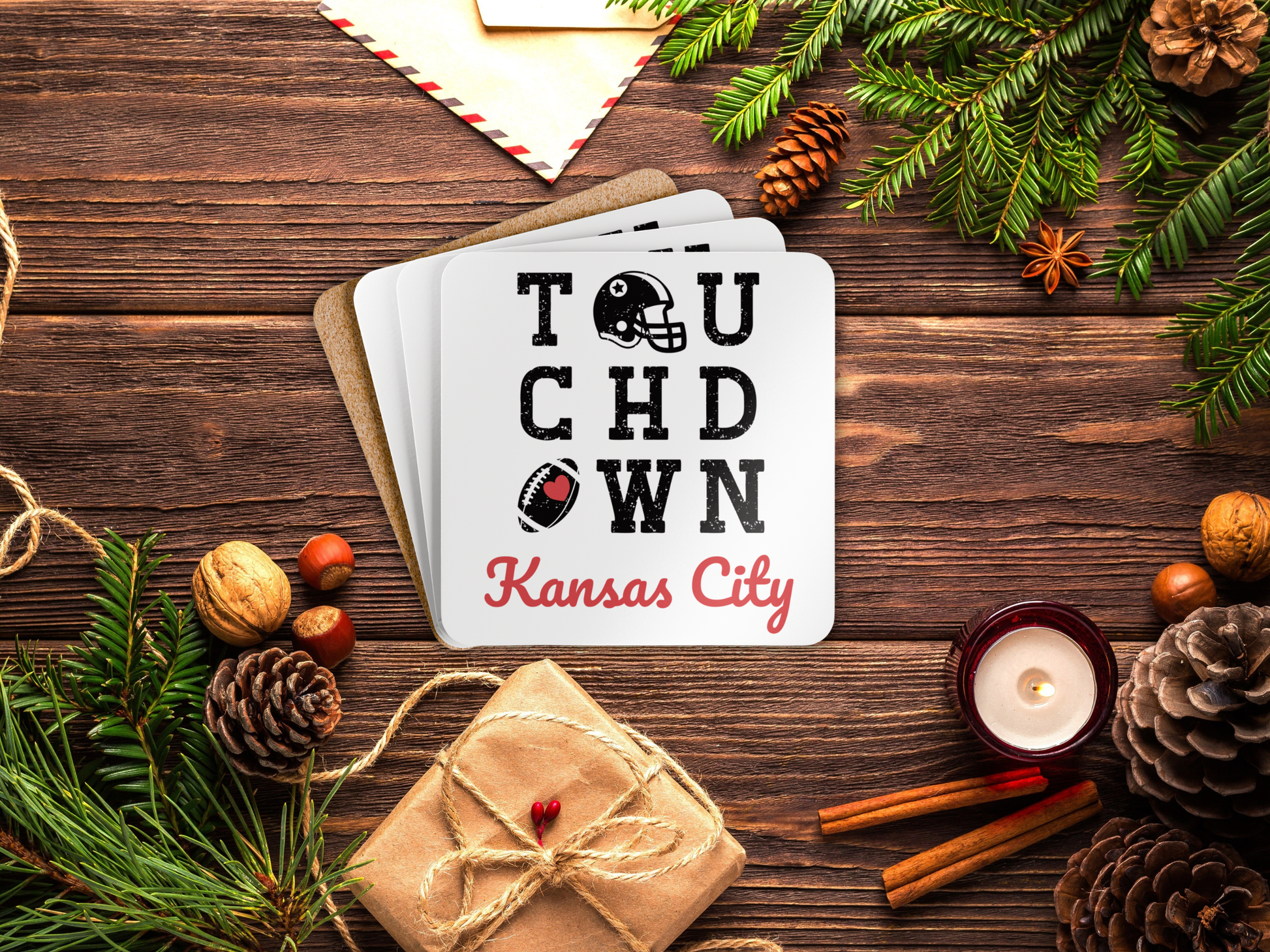 Coaster set with 'TOUCHDOWN Kansas City' text on a wooden surface with Christmas decorations.