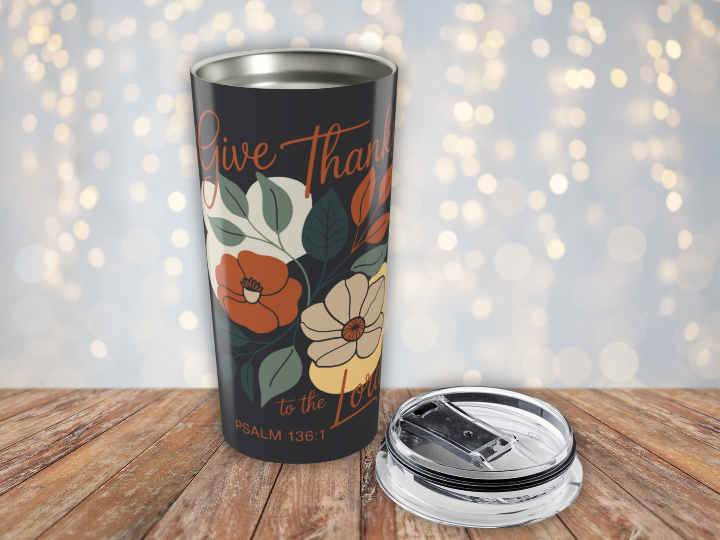 Tumbler with floral design and text on a wooden surface with a blurred light background