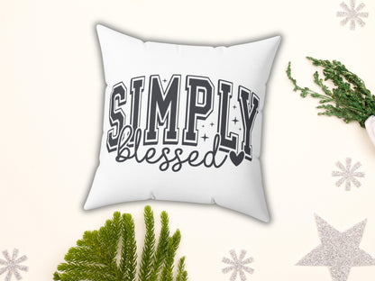 White pillow with 'Simply Blessed' text on a decorative background with greenery and snowflakes.