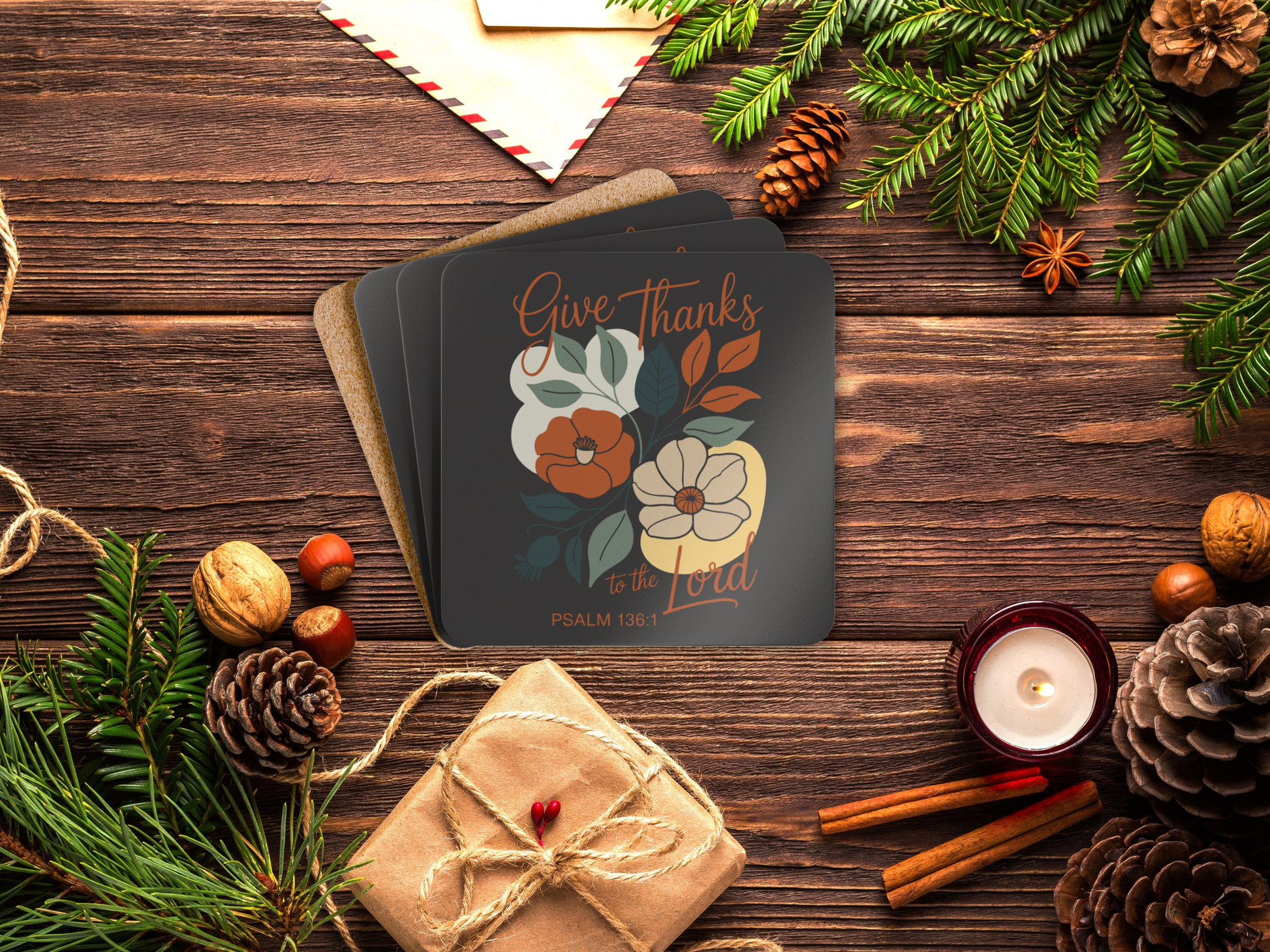Coaster set with floral design and 'Give Thanks' text on a wooden surface with festive decorations.
