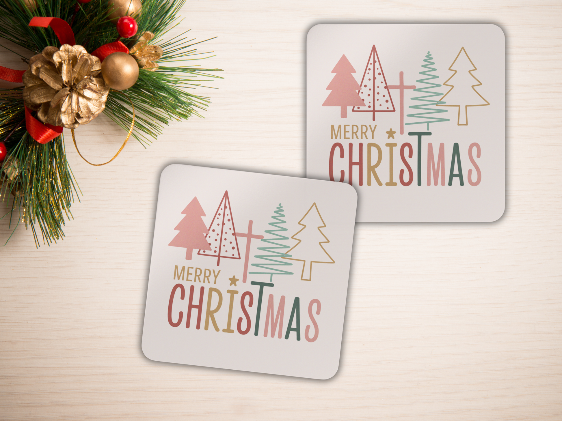 Two Christmas-themed coasters with trees and 'Merry Christmas' text on a light surface with decorative elements.
