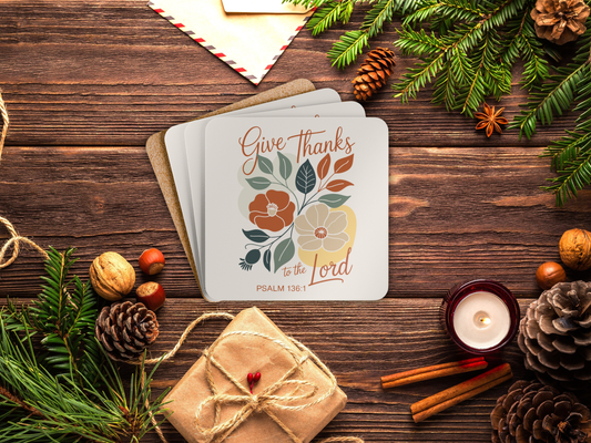 Coaster set with floral design and text on a wooden surface with festive decorations.