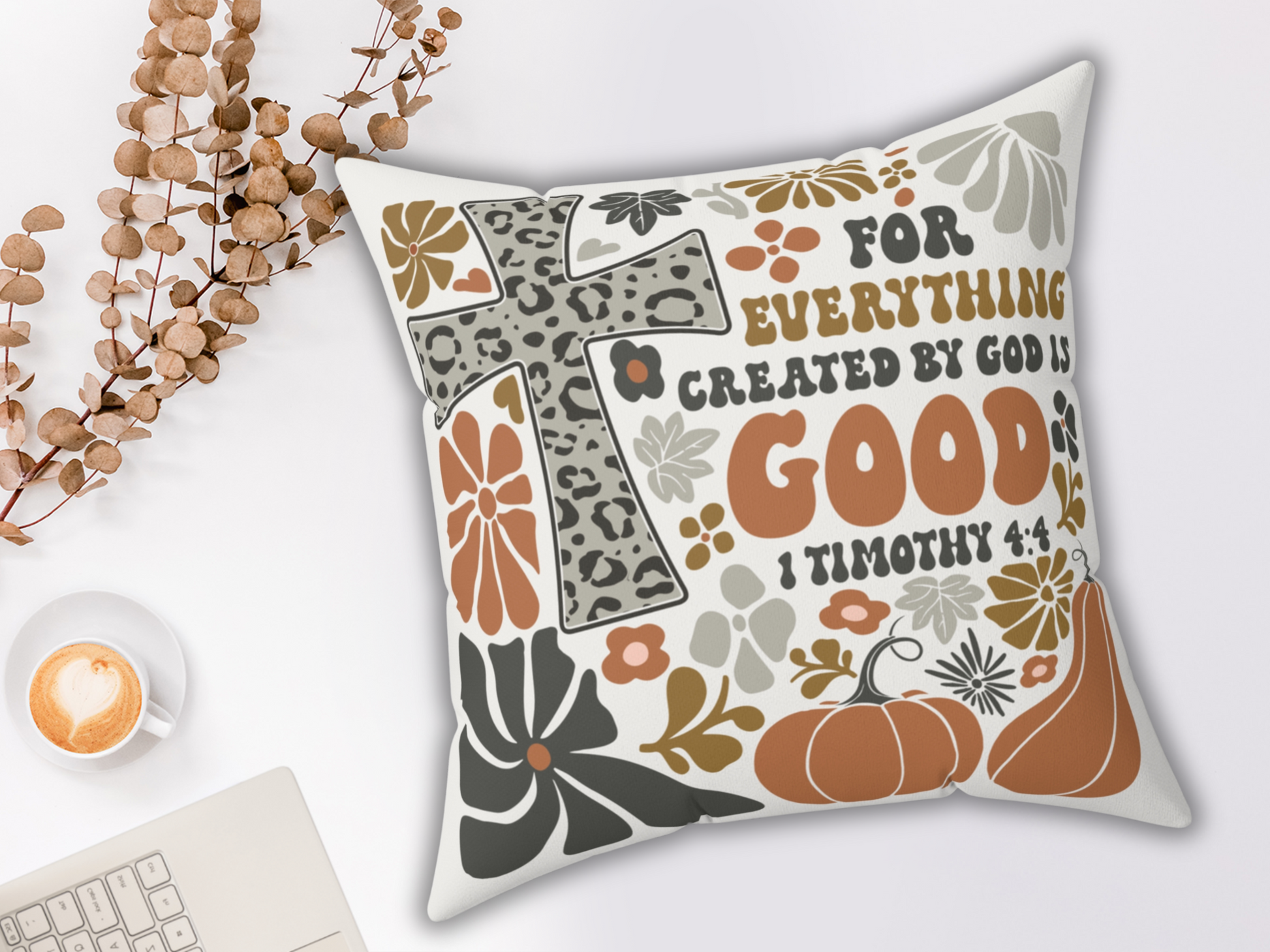 Inspirational Bible verse pillow featuring “For everything created by God is good” design, styled with eucalyptus, latte, and keyboard on white background.