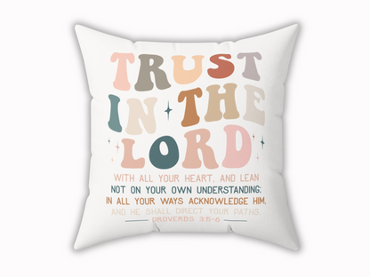 White throw pillow with colorful text “Trust in the Lord” and Proverbs 3:5-6 scripture, displayed on a plain background.