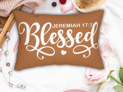 Scripture pillow on a white surface with pink mug, rose, knit blanket, and pearls for a soft cozy vibe.