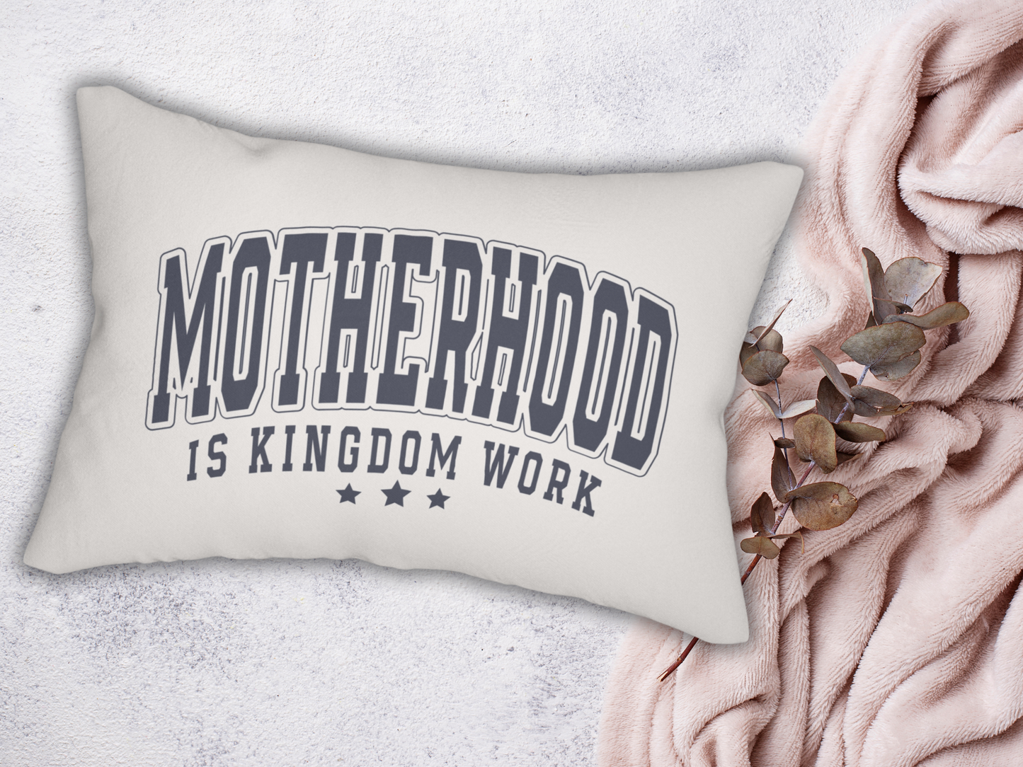 Scripture pillow with bold lettering placed on a soft blush throw with eucalyptus accents.