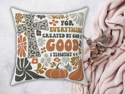 Decorative fall pillow with 1 Timothy 4:4 verse, leopard cross, pumpkins, and florals, styled on blush pink blanket with eucalyptus branch.