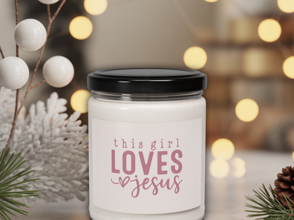 Candle jar with 'this girl loves Jesus' text on a blurred festive background