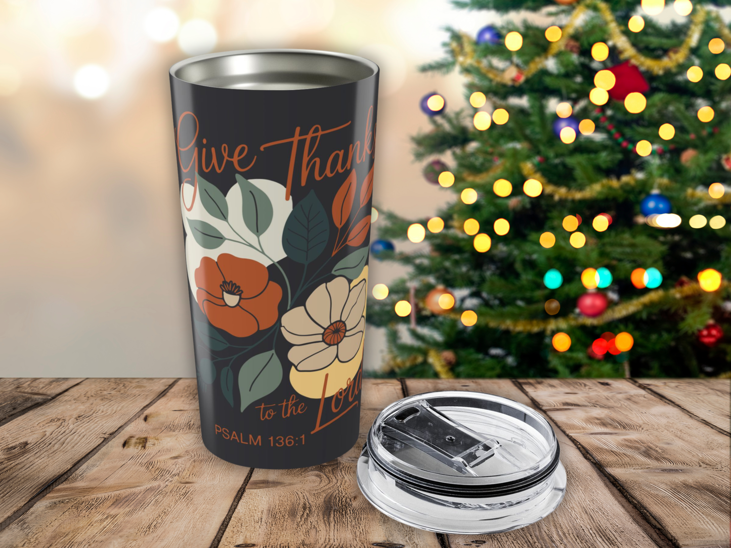 Tumbler with floral design and text in front of a decorated Christmas tree