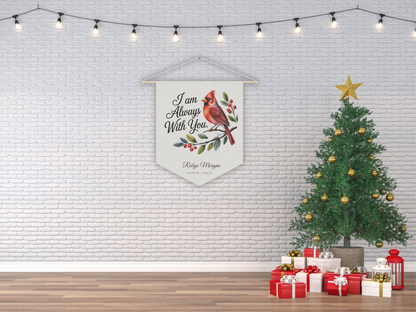 Decorative banner with cardinal design hanging on a white brick wall with a Christmas tree and presents below.