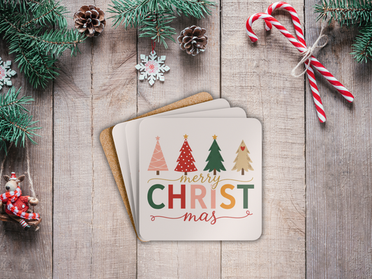 Christmas card with colorful trees and 'Merry Christmas' text on a wooden surface with festive decorations.