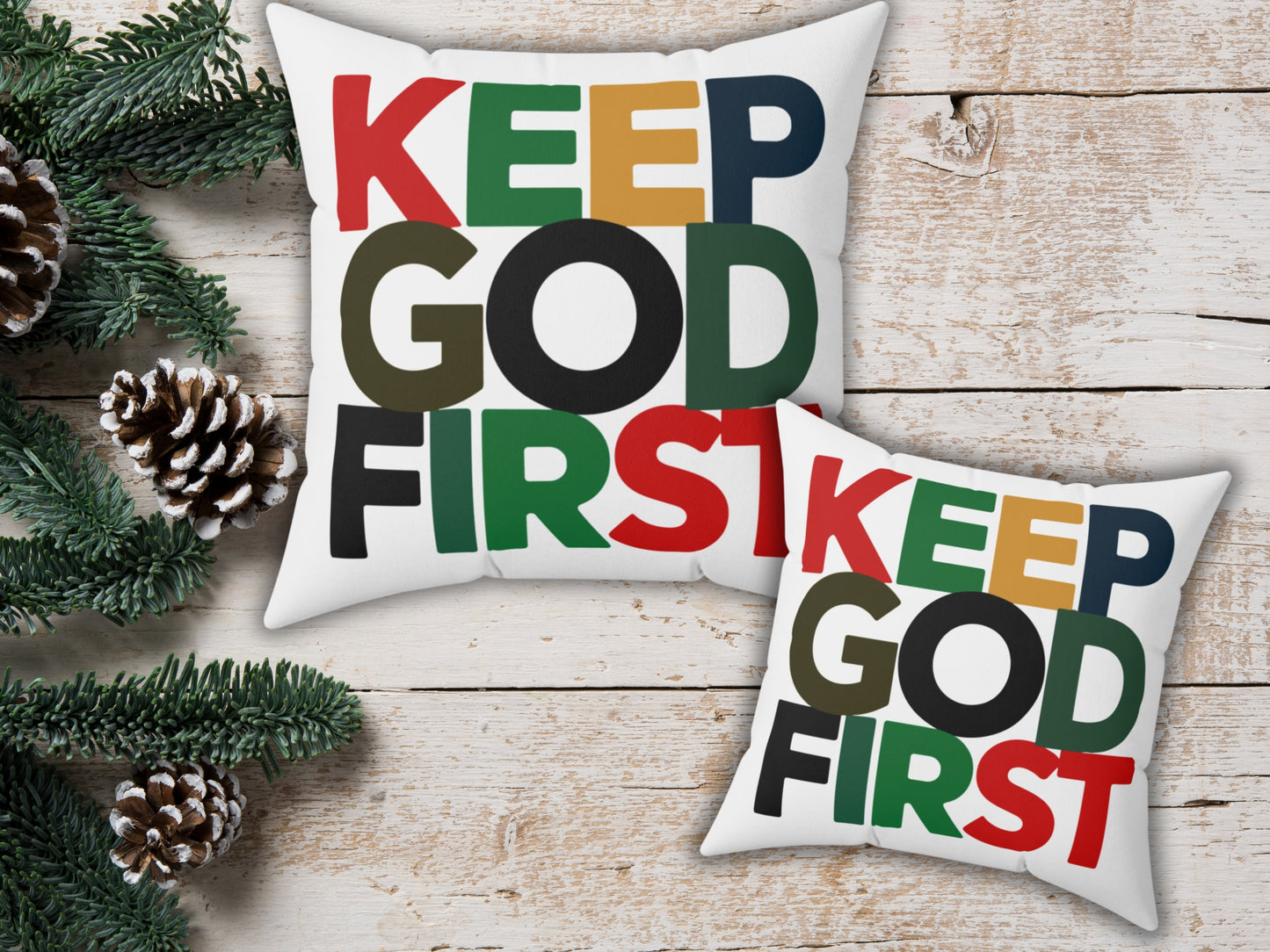 Two pillows with 'KEEP GOD FIRST' text on a wooden surface with Christmas decorations.