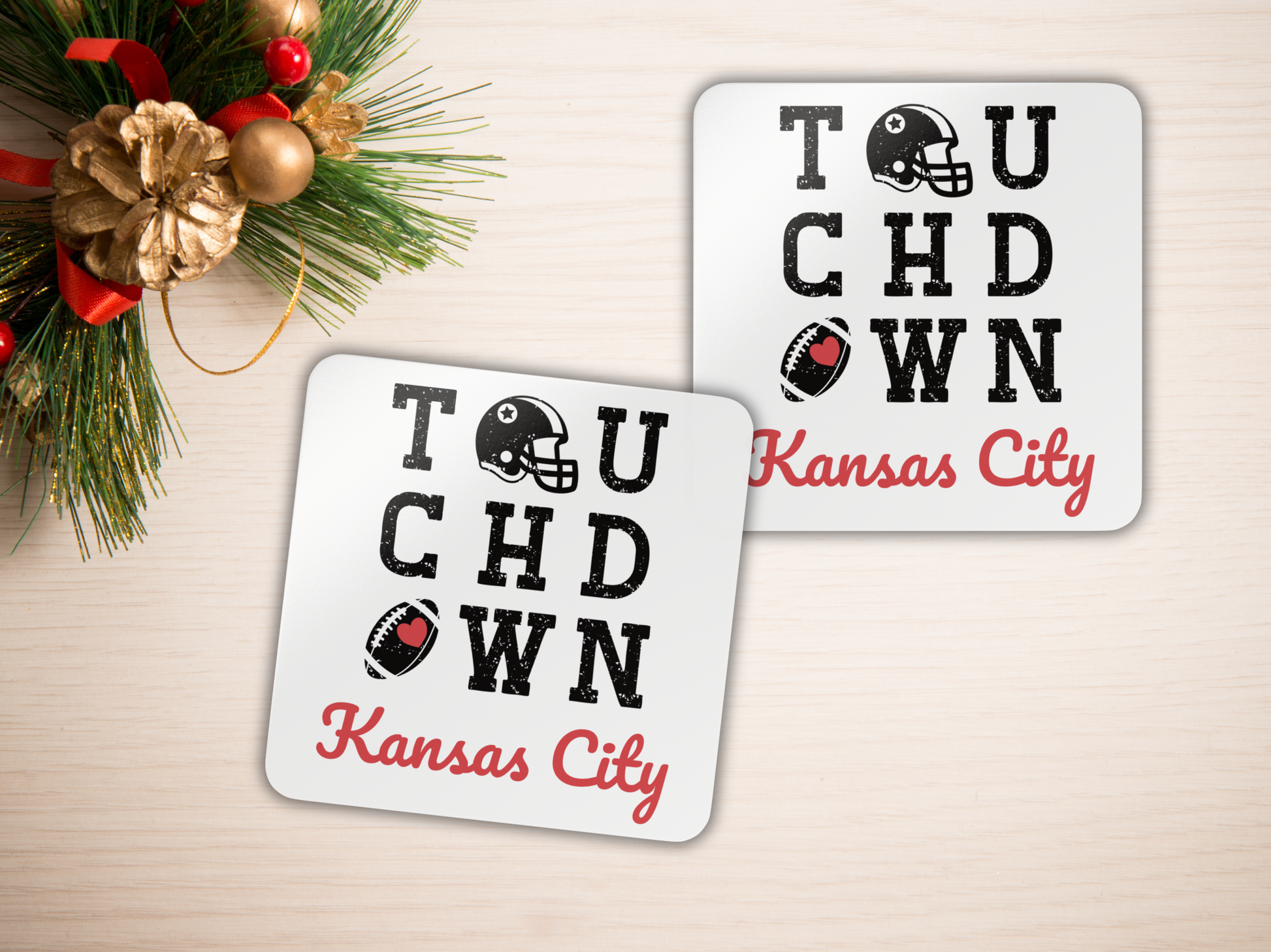Two 'Touchdown Kansas City' coasters on a light surface with holiday decorations.