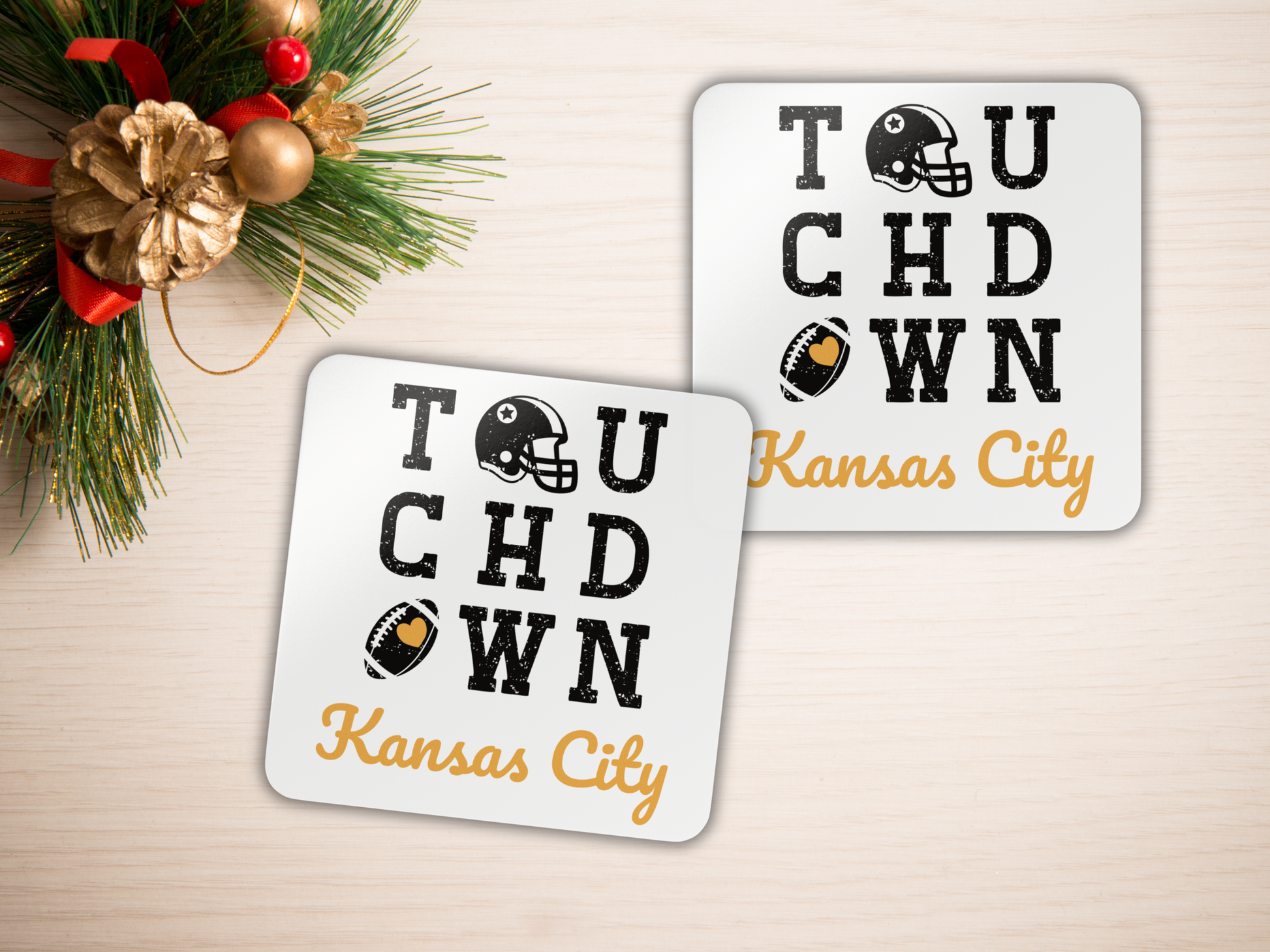 Two 'Touchdown Kansas City' coasters on a light surface with holiday decorations.