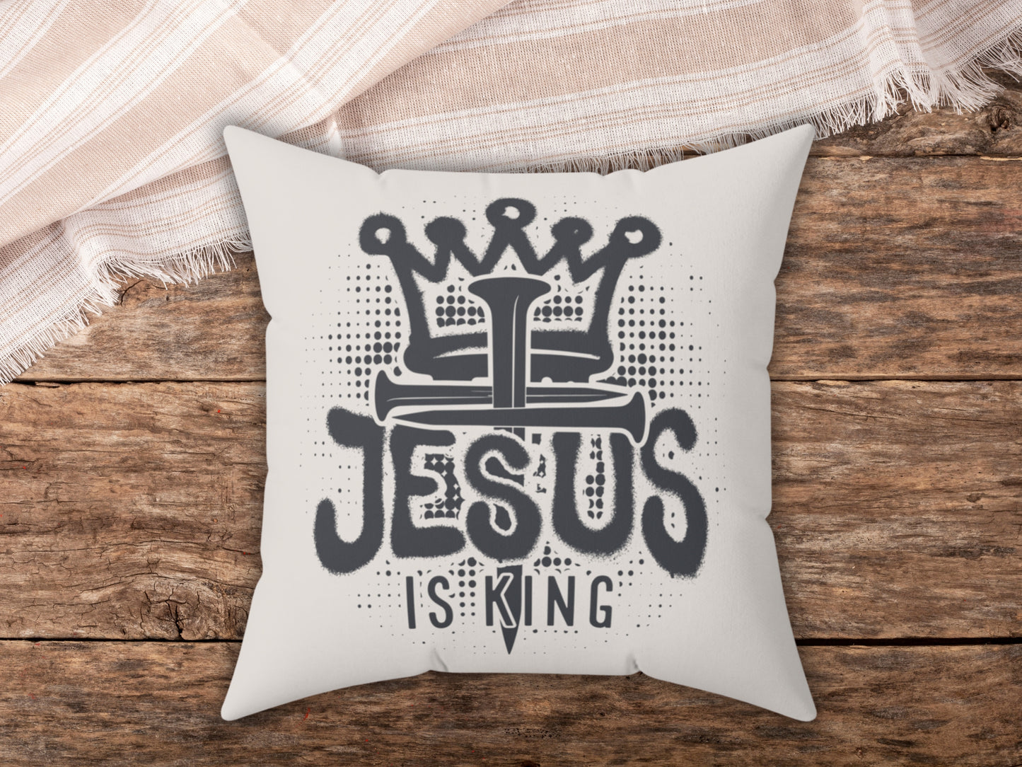 Pillow with 'Jesus is King' design on a wooden surface