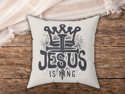 Pillow with 'Jesus is King' design on a wooden surface