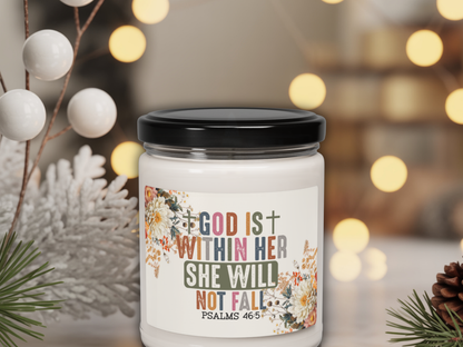 Candle jar with motivational quote and decorative elements on a blurred background