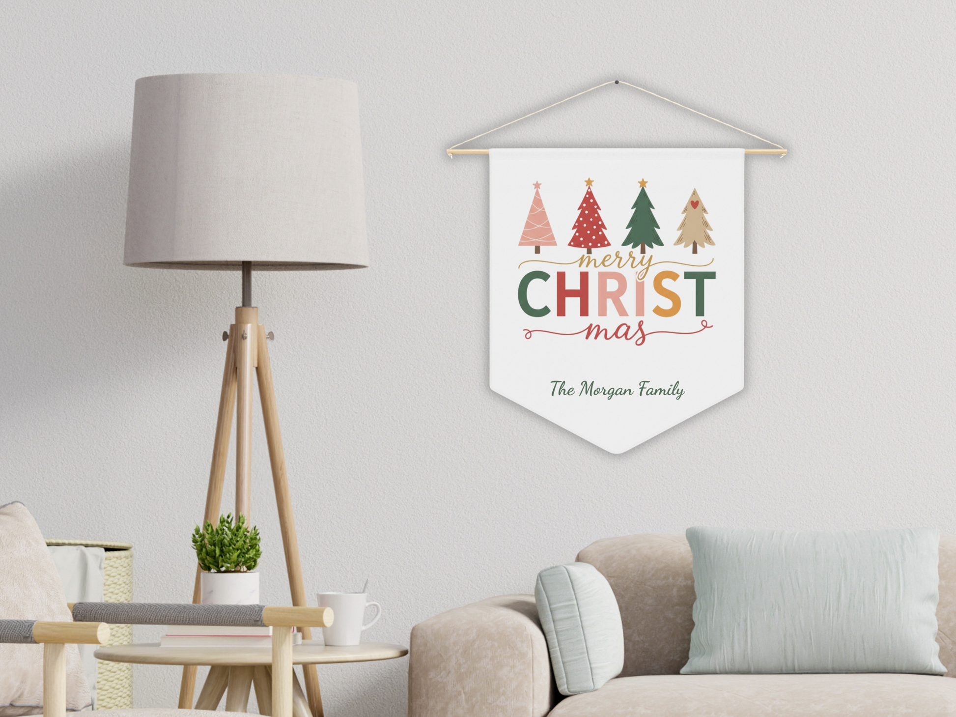 Decorative Christmas pennant with colorful trees and text hanging on a wall in a living room.