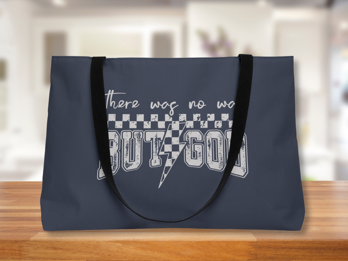 Image Alt Text Generator said:

Navy blue tote bag with “There was no way BUT GOD” design, black straps, displayed on a wooden surface with blurred bright indoor background.