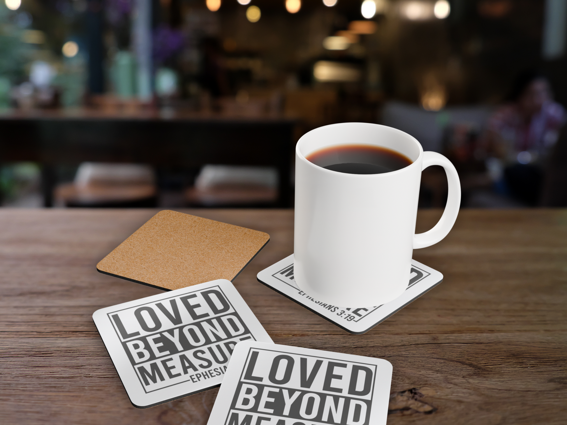 Coasters displayed in a cozy café scene with a white mug of coffee, showing cork backing and scripture design.