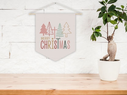 Decorative Christmas banner with trees and 'Merry Christmas' text on a wooden surface with a plant.