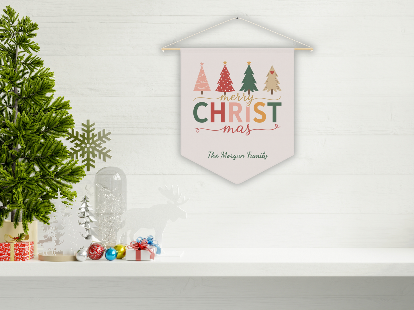 Decorative wall hanging with 'Merry Christmas' text and trees, placed on a shelf with festive decor.