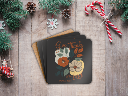 Stack of coasters with floral design and text on a wooden surface with Christmas decorations.