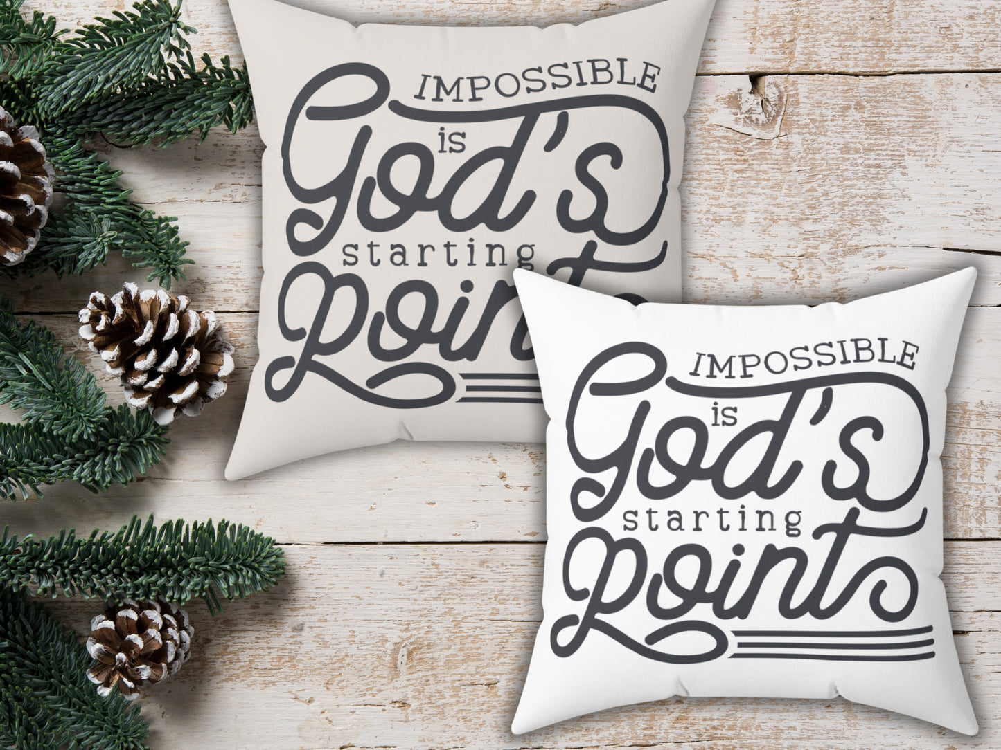 Two pillows with motivational quote on a wooden surface with Christmas decorations.