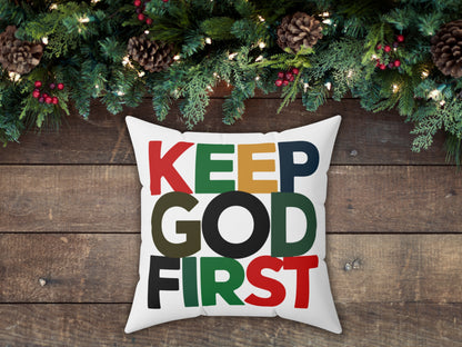 Decorative pillow with 'KEEP GOD FIRST' text on a wooden background with Christmas decorations.