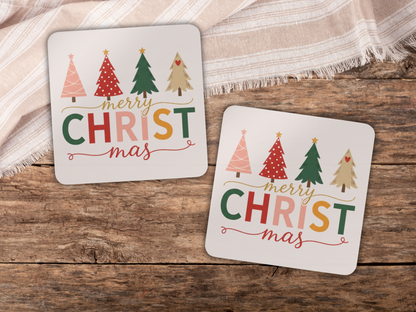 Two Christmas-themed coasters with colorful trees and 'Merry Christmas' text on a wooden surface.