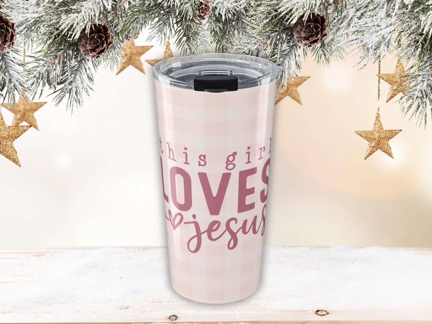 Tumbler with 'This girl loves Jesus' text against a Christmas-themed background