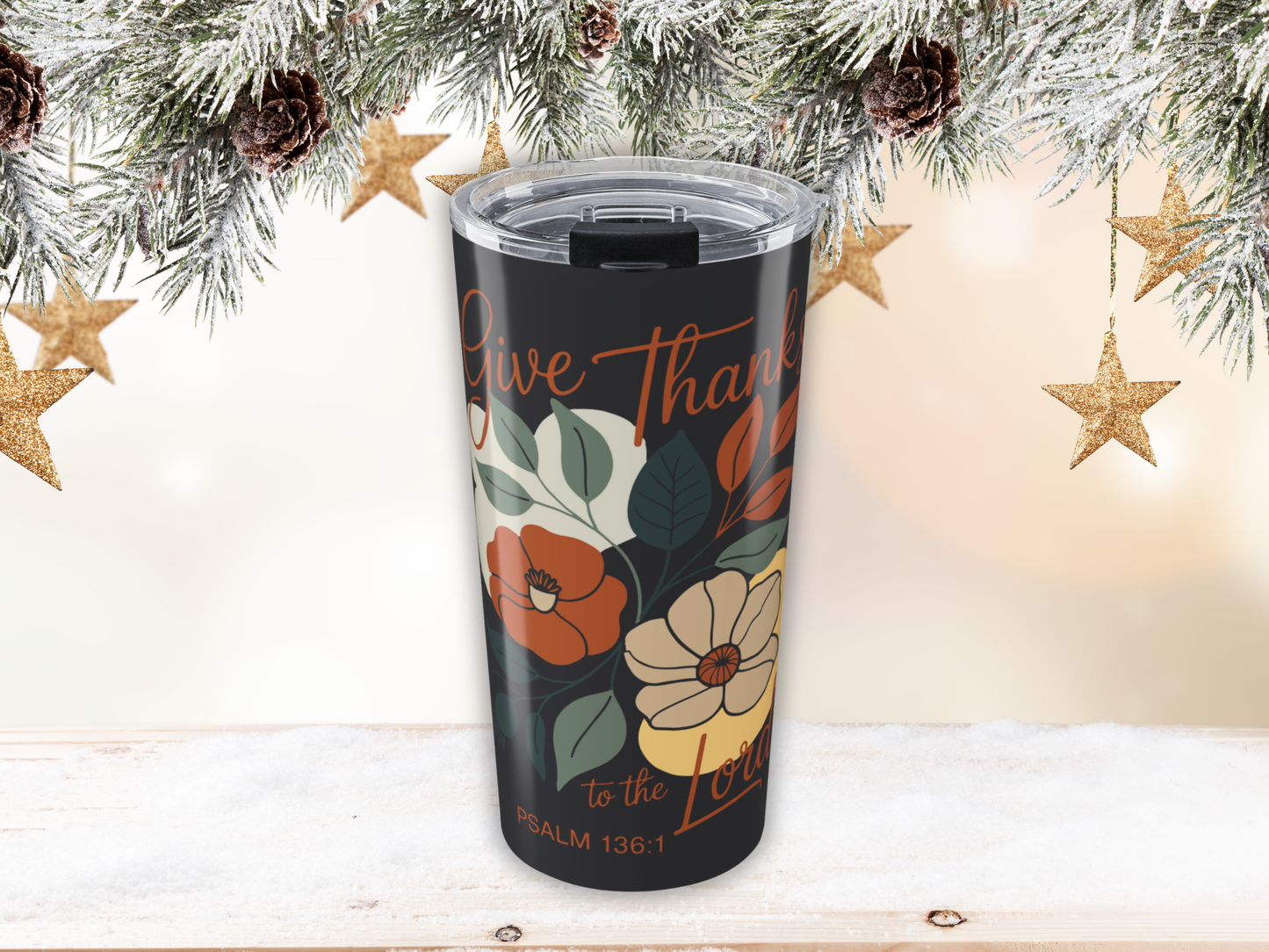 Floral tumbler with 'Give Thanks' text against a Christmas-themed background