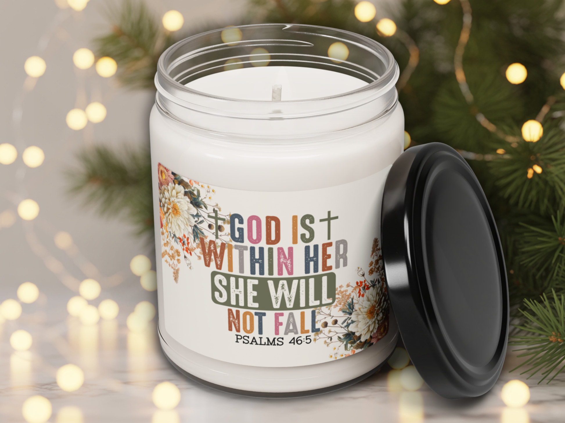 Candle jar with motivational quote and floral design on a blurred festive background