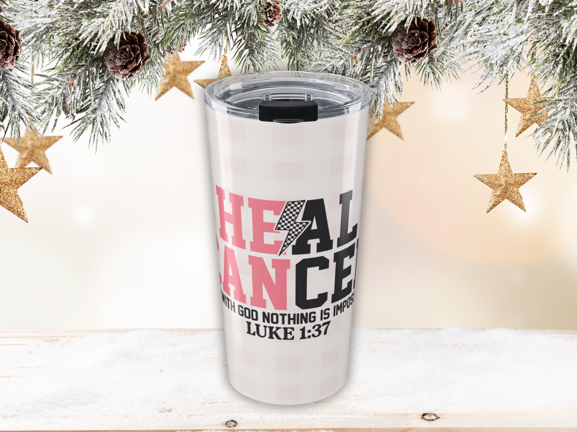 Pink plaid tumbler with motivational quote against a festive background