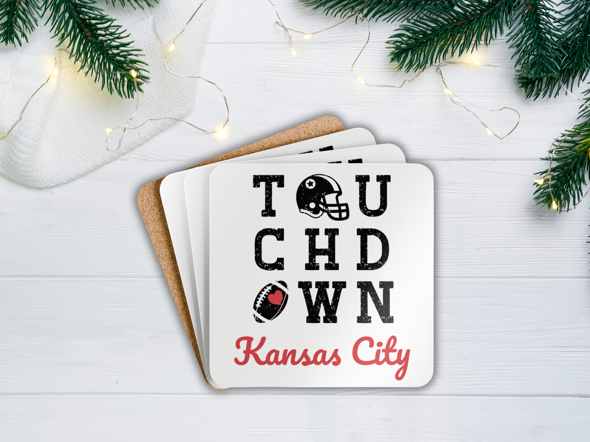 Coasters with 'Touchdown Kansas City' text on a white surface with Christmas decorations.