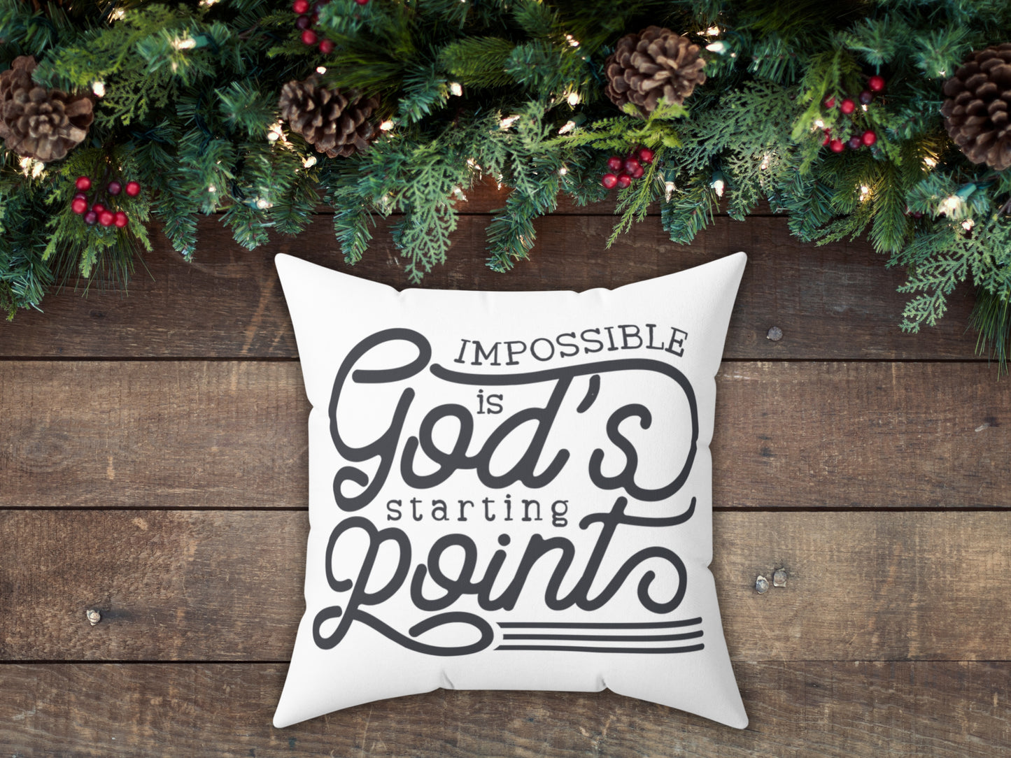Decorative pillow with motivational quote on a wooden surface with Christmas decorations.