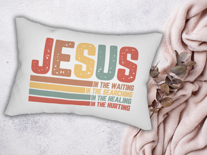 Pillow on a soft textured surface with a blush blanket and eucalyptus branch.