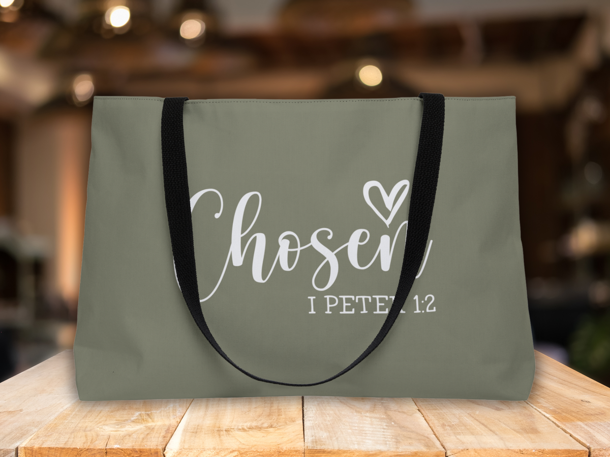 Scripture tote bag displayed on a wooden table with warm blurred background lighting.