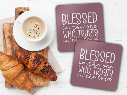 Two coasters beside coffee and croissants on a wooden board over a white tabletop.