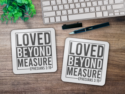 Two scripture coasters on a wooden desk beside a keyboard, pen, and potted plant.