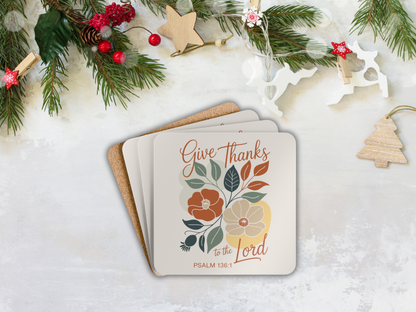 Stack of coasters with floral design and text 'Give Thanks to the Lord' on a snowy background with Christmas decorations.