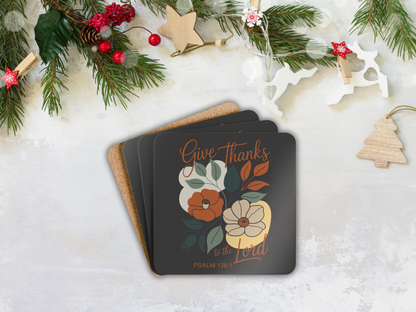 Stack of coasters with floral design and 'Give Thanks' text on a snowy background with Christmas decorations.