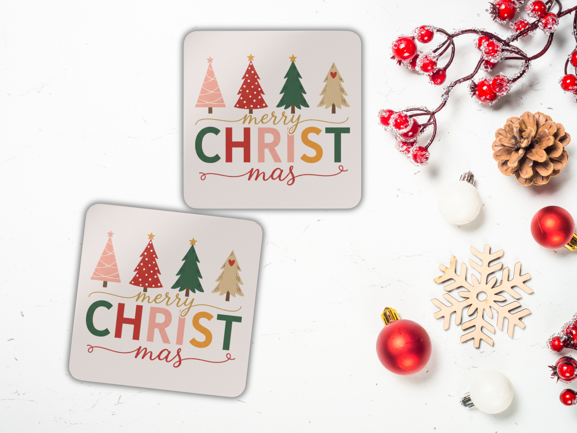 Two Christmas-themed coasters with colorful text and tree designs, surrounded by festive decorations on a white background.