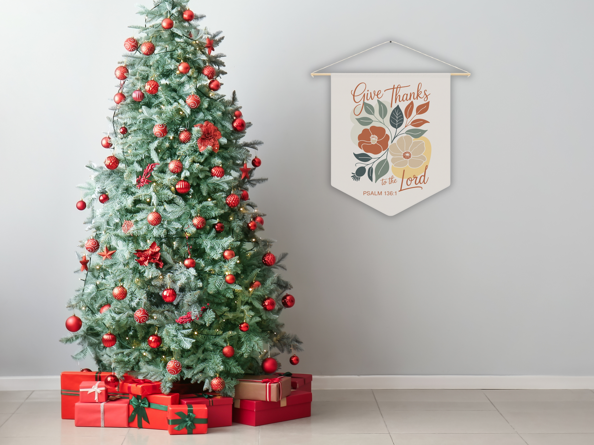 Decorated Christmas tree with red ornaments and presents, next to a wall hanging with 'Give Thanks' text.