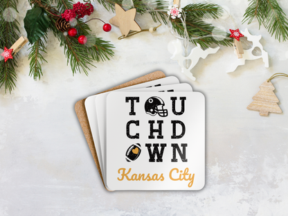 Stack of coasters with 'Touchdown Kansas City' text on a snowy background with Christmas decorations.