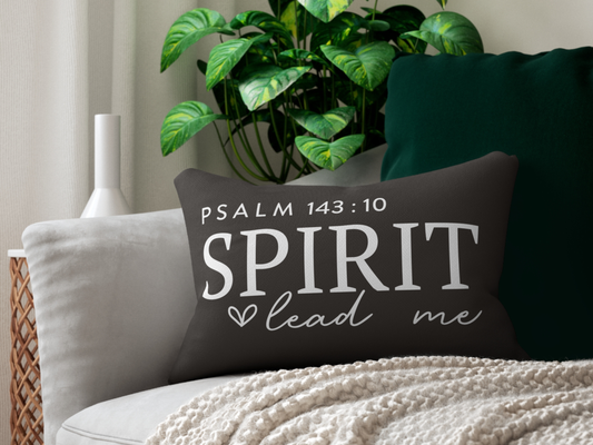 Decorative pillow with 'Psalm 143:10 Spirit lead me' text on a couch with a plant in the background.