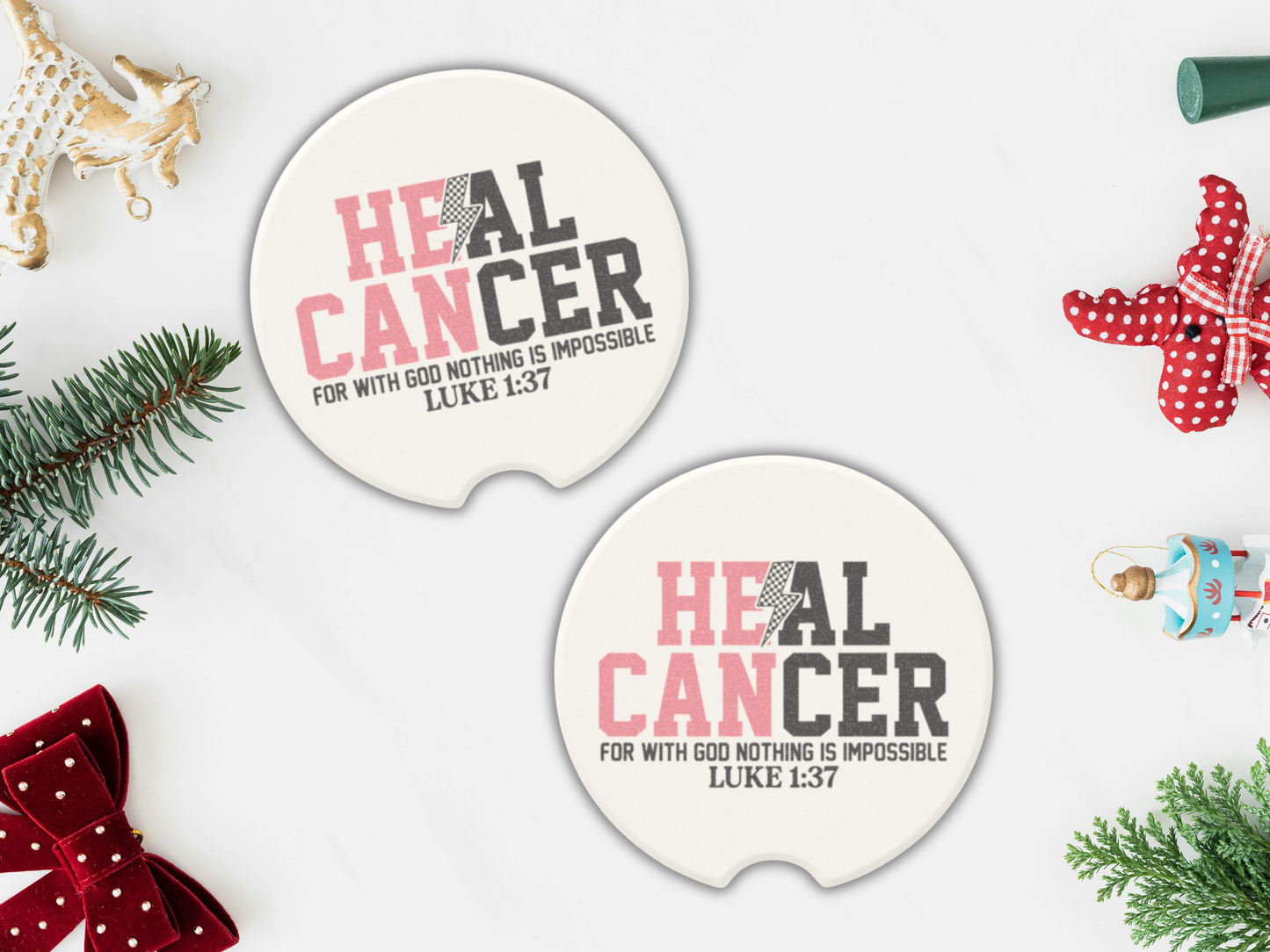 Two 'HEAL CANCER' car coasters with Christmas decorations on a white background