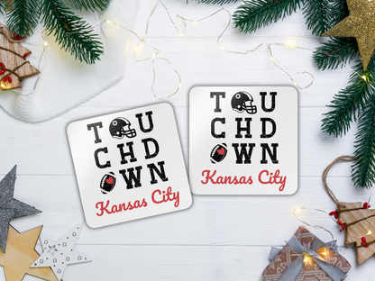 Two 'Touchdown Kansas City' coasters on a festive background with Christmas decorations.