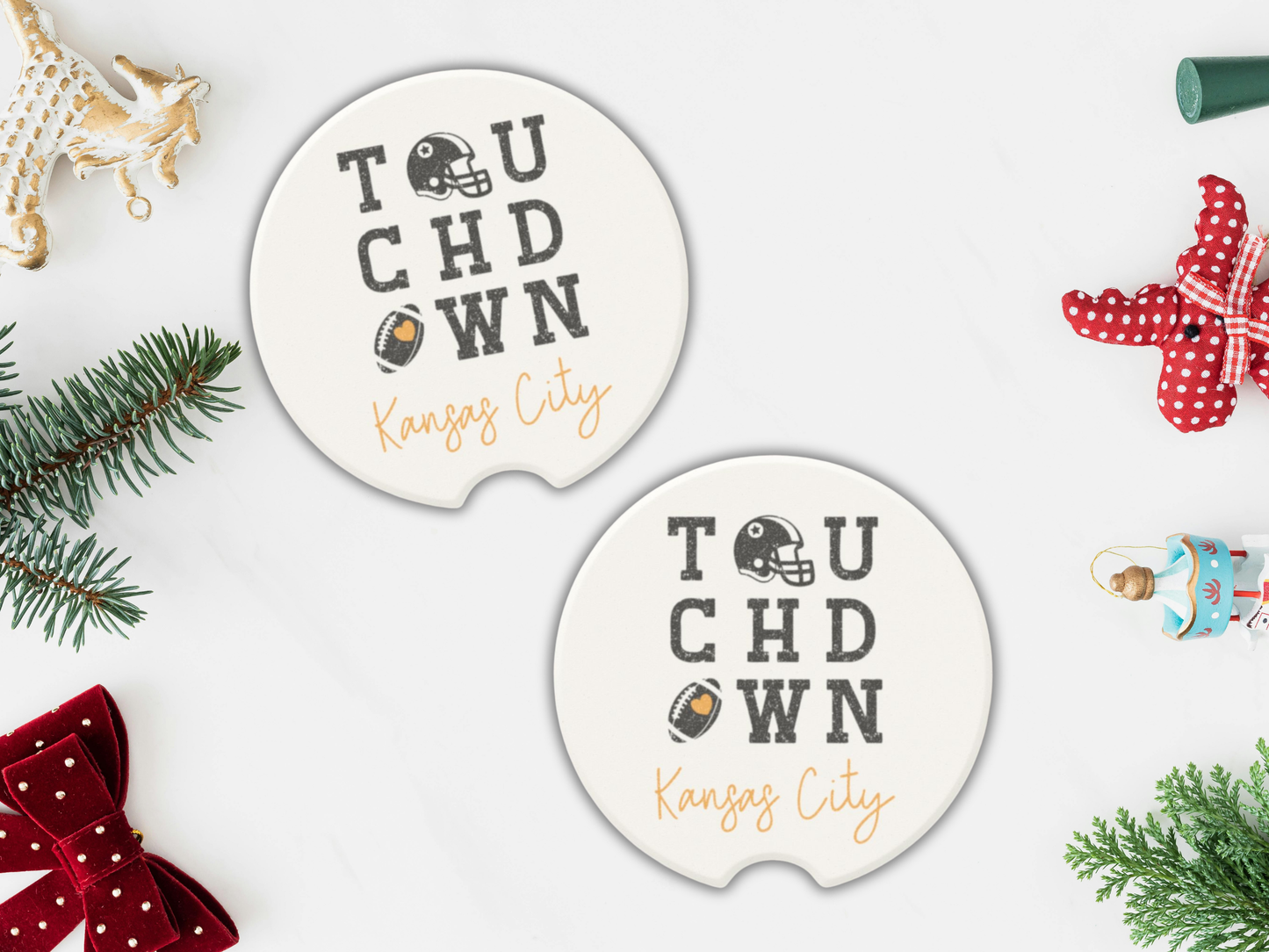 Two 'Touchdown Kansas City' coasters on a white surface with Christmas decorations.