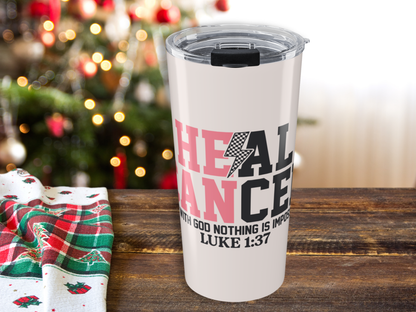 Pink tumbler with motivational quote on a wooden table with a Christmas tree in the background